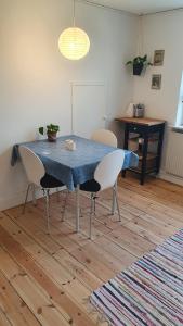a dining room table with chairs and a blue table cloth at Hyllemose Guesthouse in Lille Skensved +9 photos