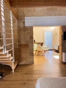 a living room with a stone wall and a staircase at Petra dimora leccese in Lecce
