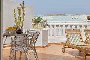 a table and chairs on a balcony with a bowl of fruit at Atlantic Nomad Retreat in Puerto del Rosario