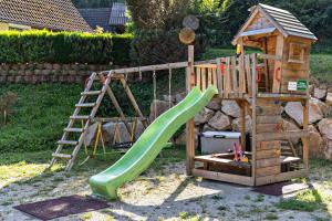 a wooden playground with a slide and a ladder at Brumichelhof in Bad Peterstal-Griesbach