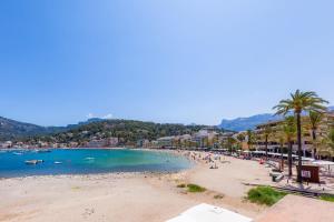 a beach with a bunch of people and palm trees at Traumblickwohnung Montemar 19 in Sóller