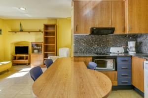 a kitchen with a wooden table in a room at Estudio P in L'Escala