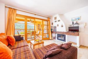 a living room with a couch and a fireplace at Traumblickwohnung Montemar 19 in Sóller