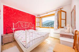 a bedroom with a white bed and a red wall at Traumblickwohnung Montemar 19 in Sóller +20 photos