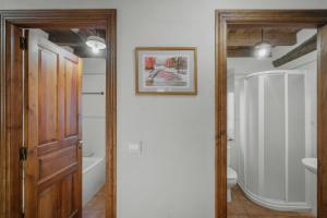 a bathroom with a wooden door and a toilet at Casa Lope in Dobres