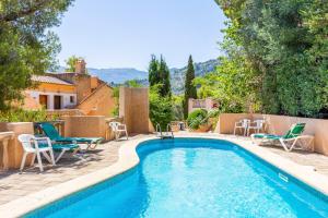 a swimming pool with lounge chairs and a swimming pool at Traumblickwohnung Montemar 19 in Sóller