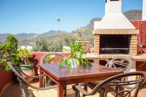 a table and chairs on a patio with a fireplace at Casa Rural Serafín in Tejeda