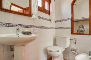 a bathroom with a white toilet and a sink at Casa Rural Serafín in Tejeda