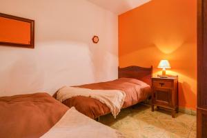 a bedroom with two beds and a night stand with a lamp at Casa Rural Serafín in Tejeda