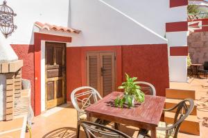 a wooden table and chairs on a patio at Casa Rural Serafín in Tejeda