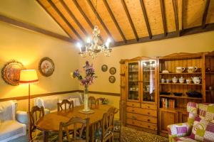 a dining room with a table and a chandelier at Casa Rural Serafín in Tejeda +16 photos