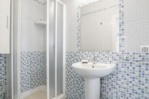 a blue tiled bathroom with a sink and a mirror at Casa Pepa in Barbate +12 photos