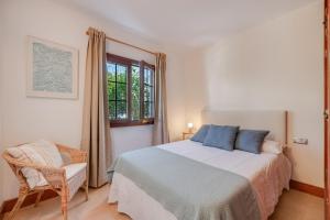 a bedroom with a bed and a chair and a window at Villa Turqué in Arrieta +22 photos