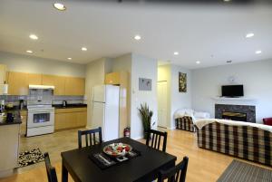 a kitchen and a living room with a table and chairs at Marpole Guest House in Vancouver