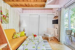 a small living room with a couch and a chair at Joli Petit Chalet La Cote d'Argent in Le Porge