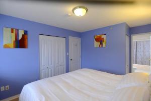 
a bedroom with a blue wall and blue curtains at Marpole Guest House in Vancouver
