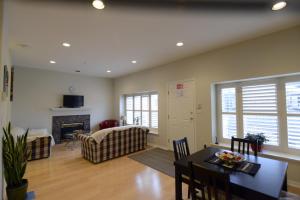 a living room with a dining table and a fireplace at Marpole Guest House in Vancouver