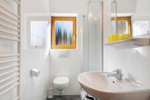 ein weißes Badezimmer mit Waschbecken und Toilette in der Unterkunft Tratterhof in Avelengo + 39 Fotos