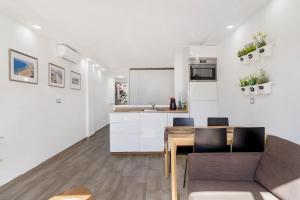 a kitchen and living room with a table and a couch at Los Molinos 202 in Maspalomas