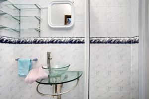 a bathroom with a glass table next to a shower at A O - Apartamento Aires in Peniche +14 photos