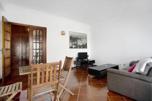 a living room with a couch and a television at A O - Apartamento Aires in Peniche