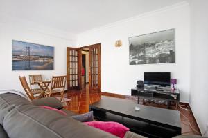 a living room with a couch and a tv at A O - Apartamento Aires in Peniche