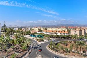 a city with a road and palm trees and buildings at Los Molinos 202 in Maspalomas