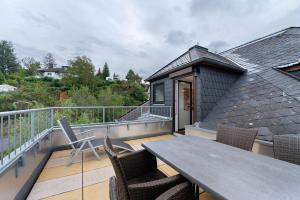 a patio with a table and chairs on a balcony at Fewo im Rosenberg mit Dachterasse in Lahnstein