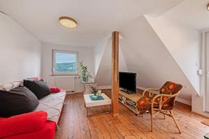 a living room with a couch and a tv at Fewo im Rosenberg mit Dachterasse in Lahnstein