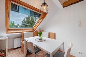 a dining room with a white table and a window at Fewo im Rosenberg mit Dachterasse in Lahnstein