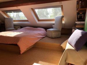 a bedroom with a bed and two windows at Maison à la campagne in Paley