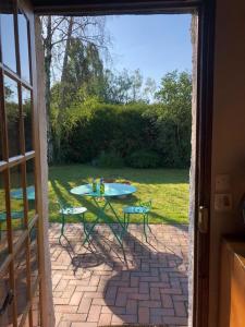 an open door to a patio with a table and chairs at Maison à la campagne in Paley
