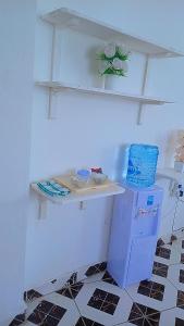 a white room with a shelf and a refrigerator at Reign homes in Watamu