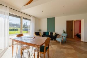 a living room with a wooden table and chairs at Gîte Le Nid Des Prés in Cressy