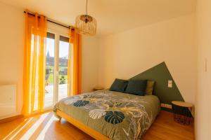 a bedroom with a bed and a large window at Gîte Le Nid Des Prés in Cressy