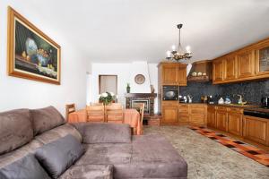 a living room with a couch and a kitchen at Apartamento Bali com Piscina in Apúlia