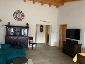 a living room with a couch and a clock on the wall at Haus Pluto in Deggenhausertal