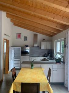 a kitchen with a table and chairs in a room at Haus Pluto in Deggenhausertal