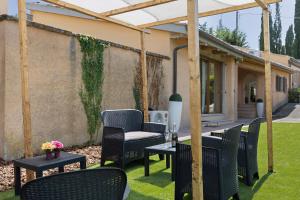 a patio with chairs and tables and a pergola at Bellavista Cottage in Barberino di Mugello