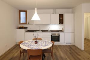 a kitchen with a table and chairs and a kitchen with white cabinets at Appartamento Torricelli in Fossombrone
