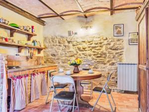 a kitchen with a table and chairs and a stone wall at Apartment Ginestra by Interhome in Perugia