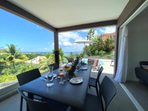 a dining room with a table and a large window at Villa APOLLINAIRE in Les Trois-Îlets