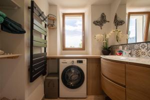 a laundry room with a washing machine and a sink at Appart Authentique et Confortable in Valderoure +23 photos