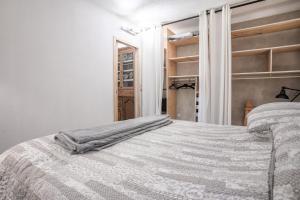 a bedroom with a bed with a blanket on it at Appart Authentique et Confortable in Valderoure