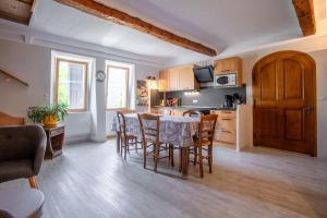 a kitchen and dining room with a table and chairs at Appart Authentique et Confortable in Valderoure