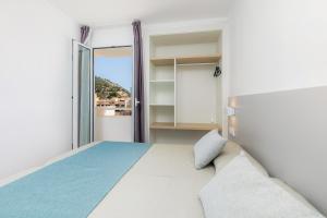 a bedroom with a bed and a large window at Apartament Massanet 2b in Canyamel