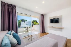 a living room with a couch and a tv at Apartament Massanet 2b in Canyamel