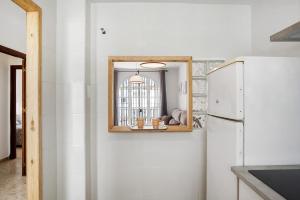a kitchen with a white refrigerator and a mirror at Apartamento Atlántico in Barbate +14 photos