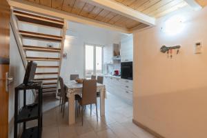 a kitchen and dining room with a table and a staircase at Seacastle Sicily in Castellammare del Golfo