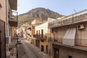 an alley with buildings and a mountain in the background at Seacastle Sicily in Castellammare del Golfo